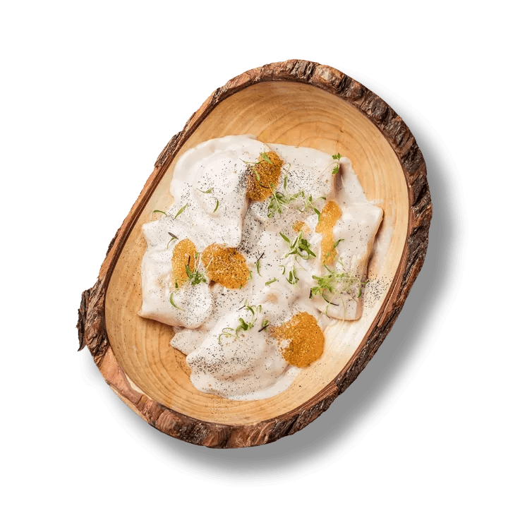 Тарілка українських вареників з начинкою з коропа та сома, поданих з копченим соусом та щучою ікрою