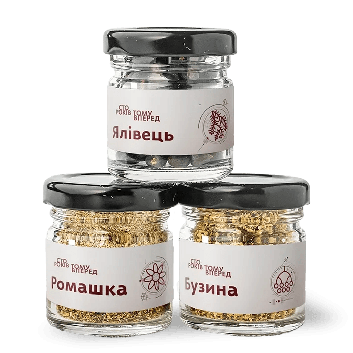 Ялівець, ромашка та бузина — традиційна українська суміш пряних трав, викладена на дерев’яній поверхні.