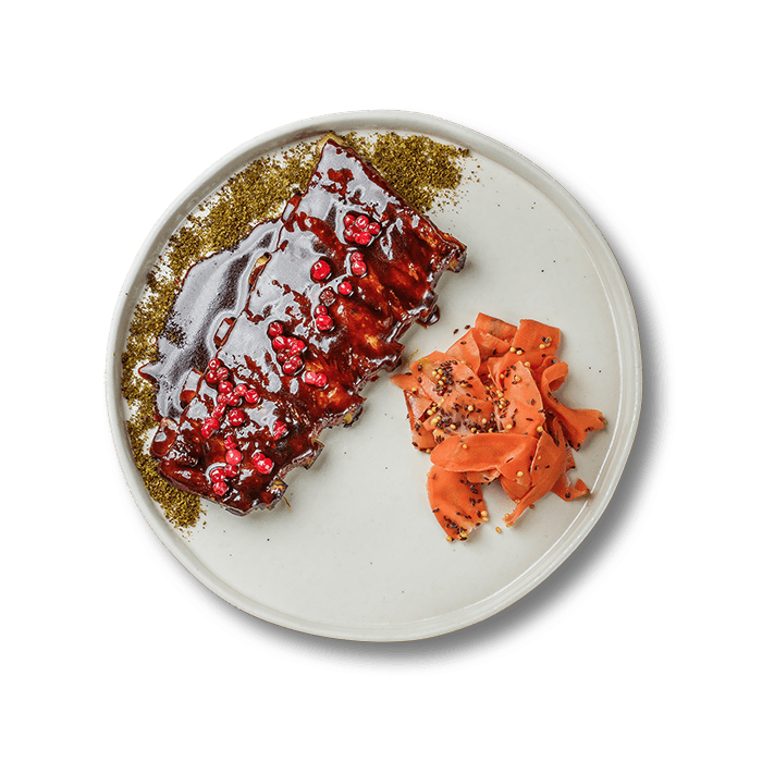 Тарілка соковитих свинячих ребер, приготованих у дров’яній печі, поданих у ресторанній подачі