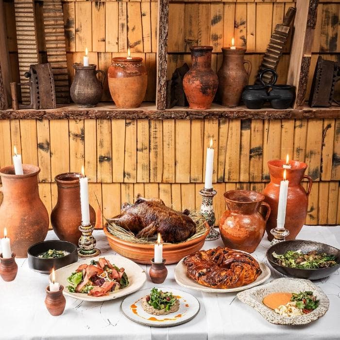 New Year’s dinner for two with duck from the restaurant ‘100 rokiv tomu vpered’: appetizers, salads, kalyta bread, tovchanka, and roasted duck with apples and cranberries.