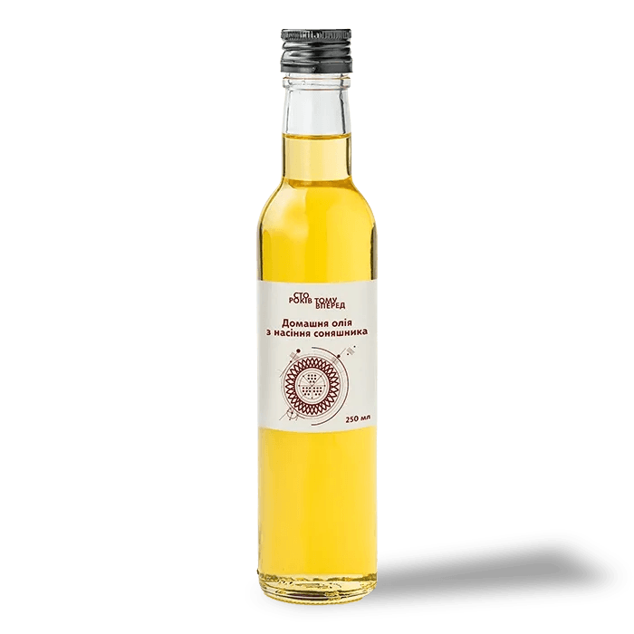 Bottle of homemade unrefined sunflower oil from Poltava, showcased with sunflower seeds and rustic elements.