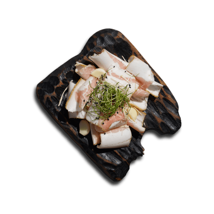 Slices of Ukrainian salo served with Drohobych salt on a wooden board