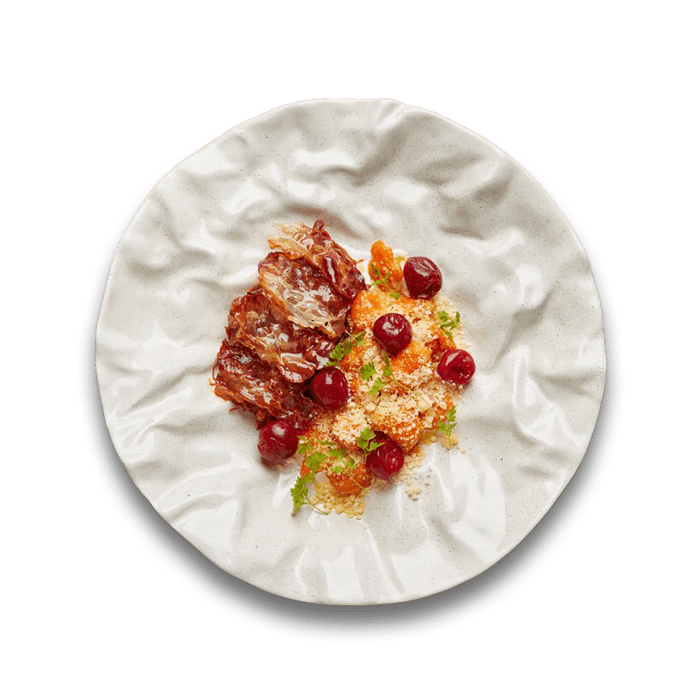 Тарілка традиційних українських галушок із начинкою з яловичини та вишень у ресторанній подачі